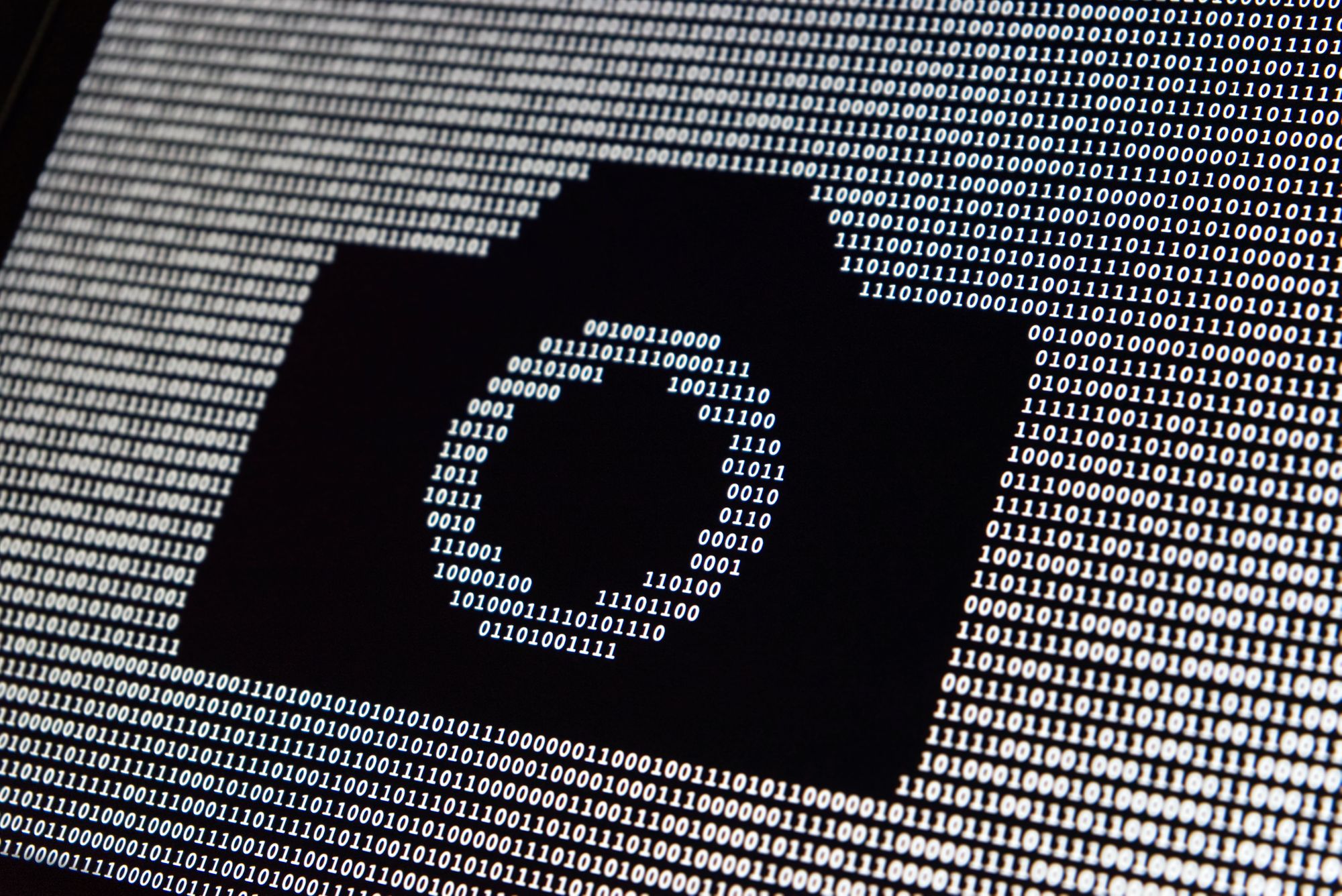 Ocean of 0s and 1s with missing digits in the shape of a camera icon.