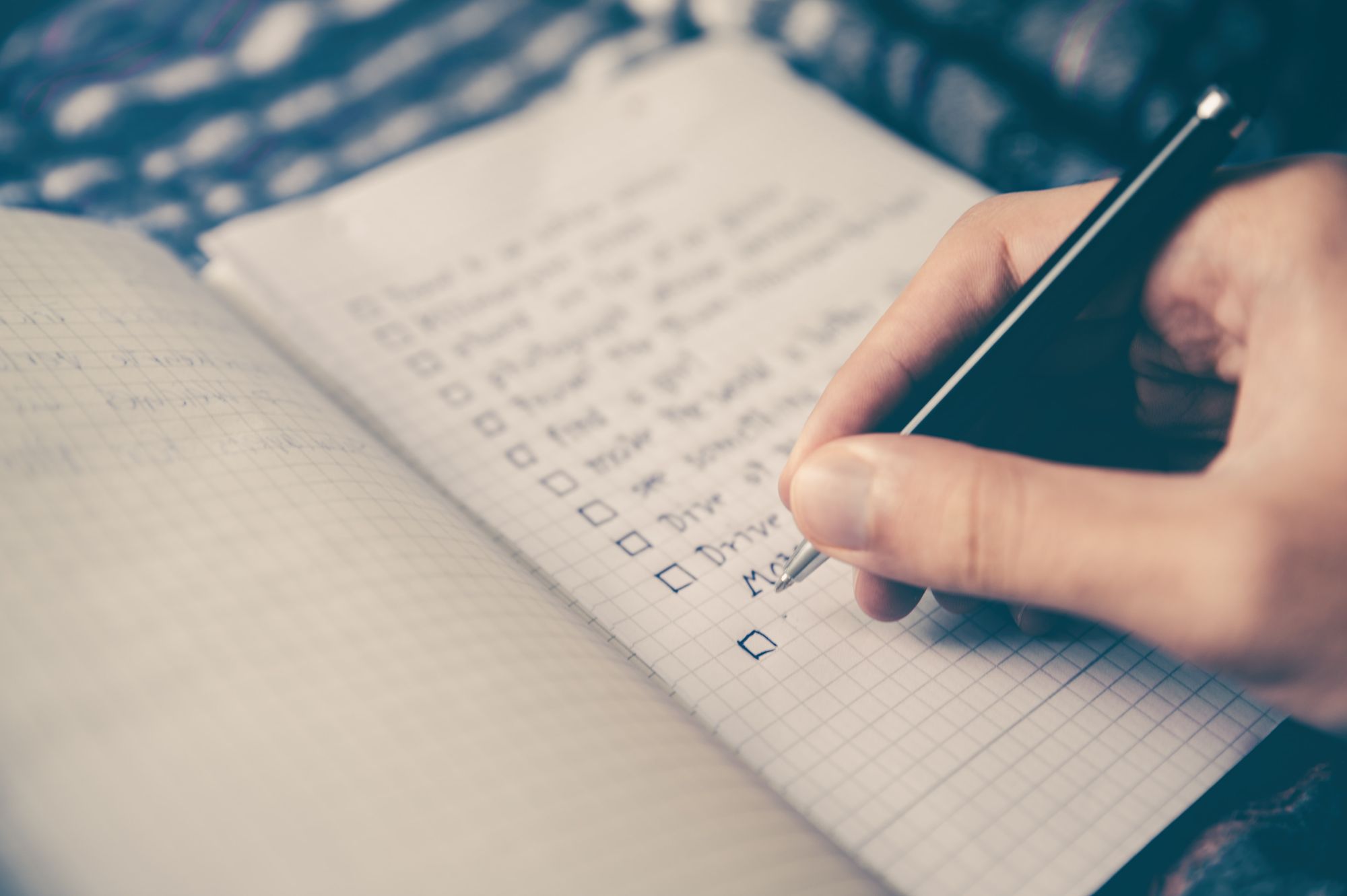 Squared notebook with a checklist on one of the pages.