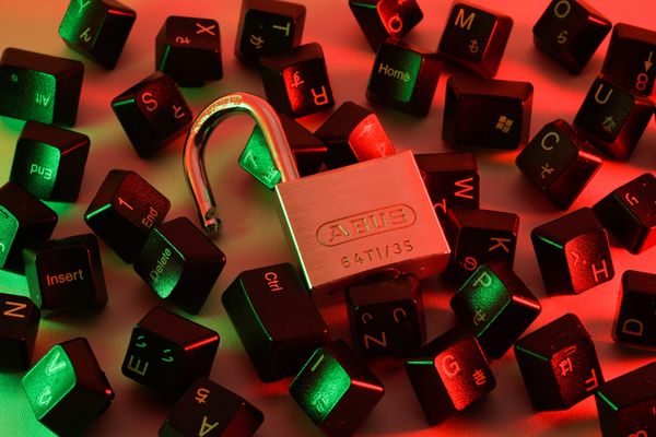 Keyboard buttons spread around an open lock.